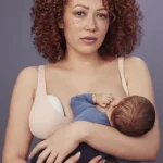 Mujer amamantando bebé con extractor de leche Elvie Pump en el otro seno